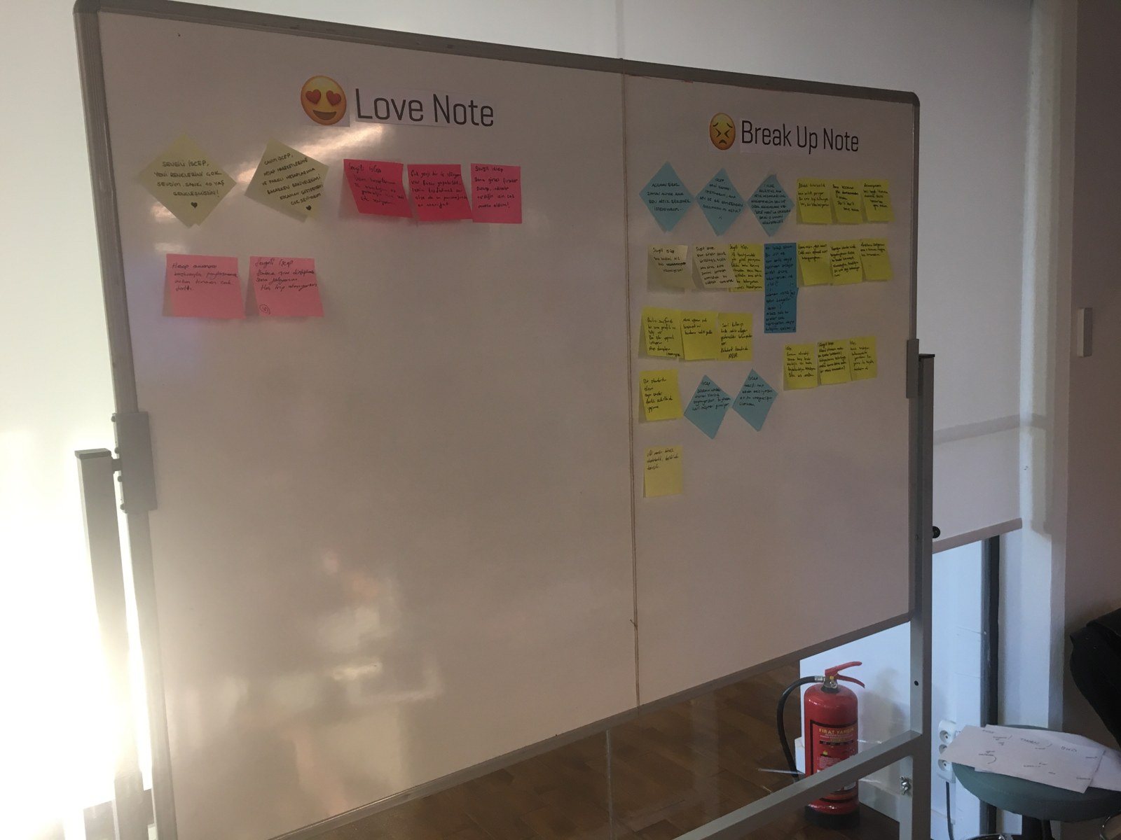 Whiteboard split into Love Note and Break Up Note; the break-up side holds far more sticky notes.
