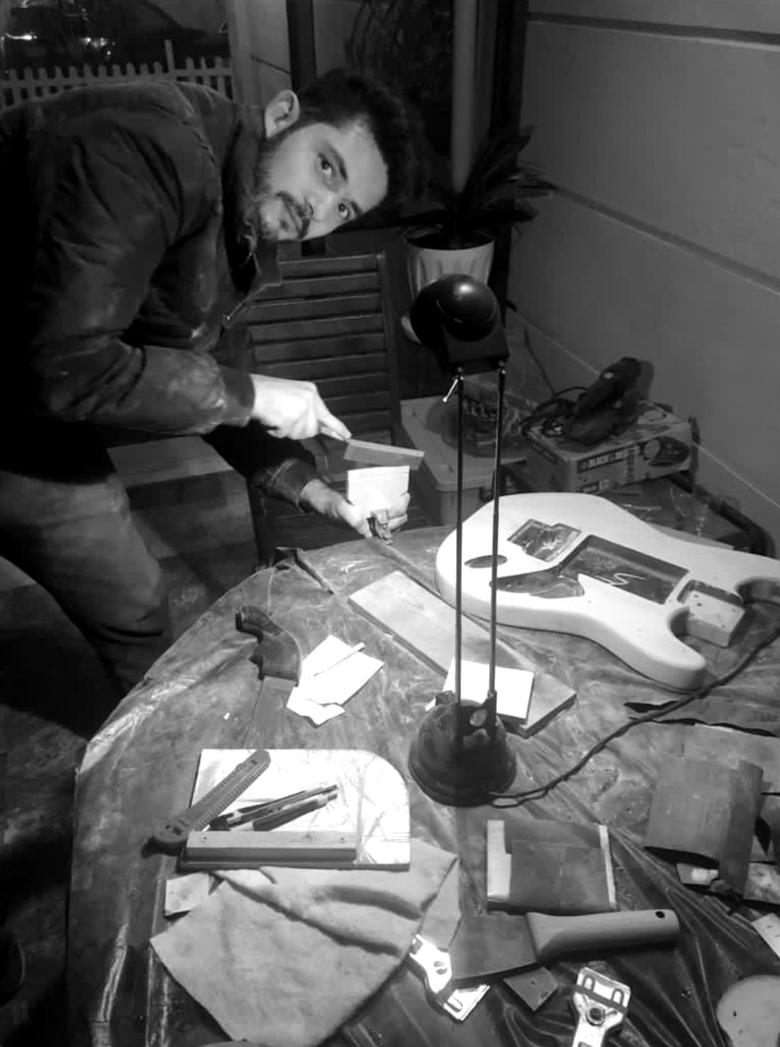 Koray filing a wooden part at his workbench